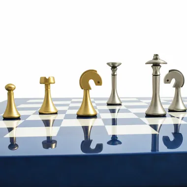 Goldene und silberne Messingfiguren aufgereiht auf dem blauen Schachbrett