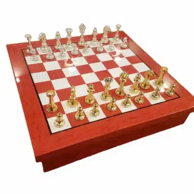 Rot-weißes Holzschachbrett mit vergoldeten und versilberten Messingfiguren in Aufstellung