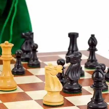 Springer und weiße Figuren gegenüber den schwarzen, grüner Beutel im Hintergrund