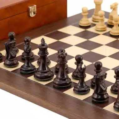 Schwarze und weiße Figuren auf dem goldfarbenen Schachbrett aufgestellt