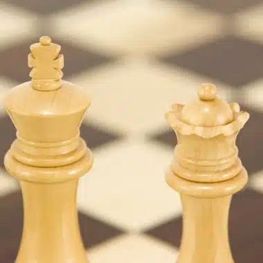 Heller König und Dame in Nahaufnahme vor dem unscharfen Schachbrett