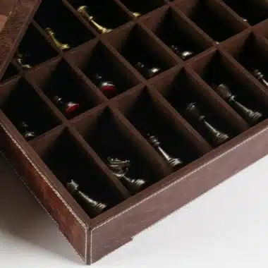 Geöffnete Lederbox mit Aufbewahrungsfächern und Schachfiguren aus Messing