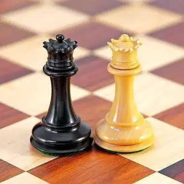 Schwarze und helle Dame des Souverain-III-Sets, einander gegenüber auf dem Schachbrett