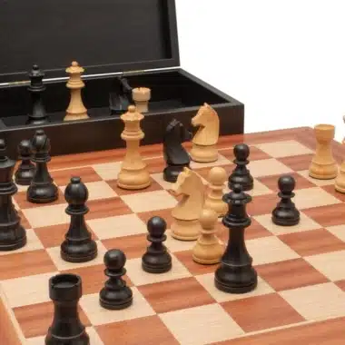 Laufende Partie auf dem Mahagoni-Schachbrett mit geöffneter Box im Hintergrund
