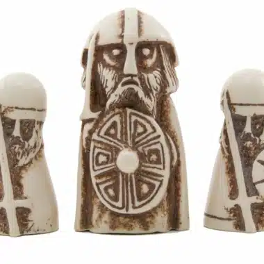 Figur des Wikingerkönigs umgeben von zwei Harzfiguren des Spiels Hnefetafl