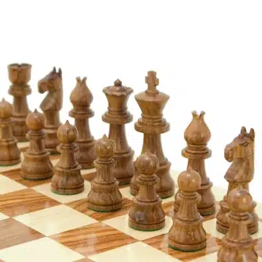 Dunkle Schachfiguren aus Sheeshamholz auf dem Schachbrett aufgereiht