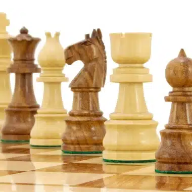 Helle und dunkle Figuren diagonal auf dem Schachbrett aufgereiht