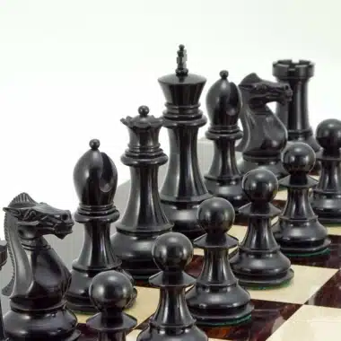 Schwarze Schachfiguren aus Ebenholz auf einem Intarsien-Schachbrett