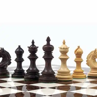 Schachfiguren aus Buchsbaum und Rosenholz aufgereiht auf dem Schachbrett