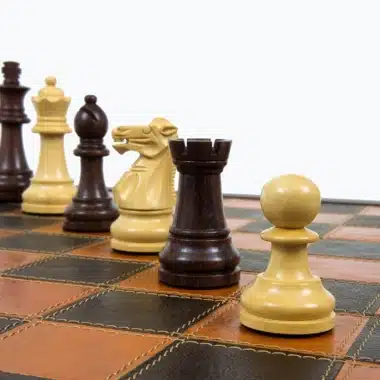 Figurenreihe aus Rosenholz und Buchsbaum in Perspektive auf dem Lederschachbrett