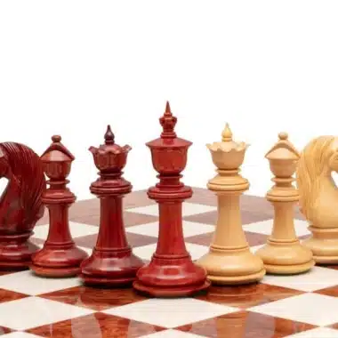 Schachfiguren aus rotem Padoukholz und hellem Buchsbaum auf dem Brett