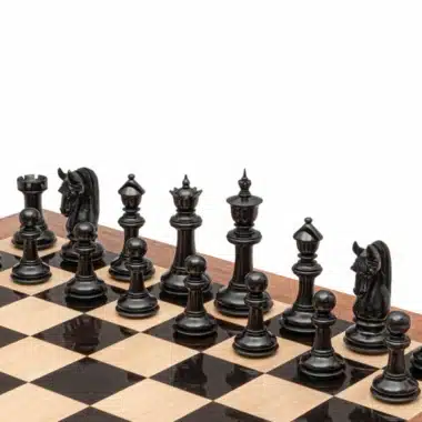 Schwarze Ebenholzfiguren des Schachspiels Braise Noire auf dem Brett aufgereiht