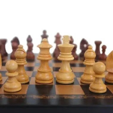 Schachfiguren aus hellem und dunklem Holz auf dem schwarzen Schachbrett aufgereiht
