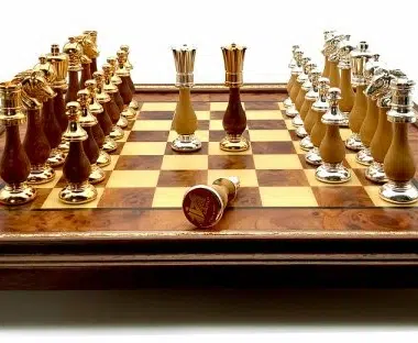 Nahaufnahme der goldenen und silbernen Figuren auf dem Schachbrett aus Ulmenholz