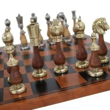 Schachfiguren aus Holz und Metall aufgereiht auf dem braunen Schachbrett