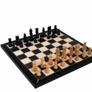 Schachspiel aus hellem und schwarzem Holz auf einem Schachbrett aus echtem Leder