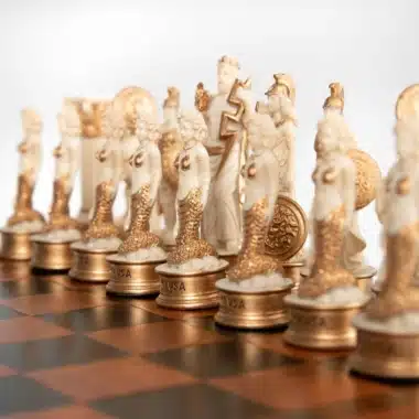 Goldene und cremefarbene Figuren auf dem Schachbrett, Perspektive zum gekrönten König