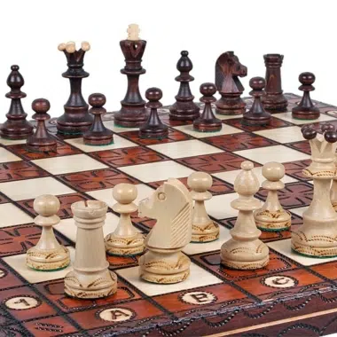 Schachfiguren diagonal angeordnet auf dem gravierten Brett, Winkelansicht