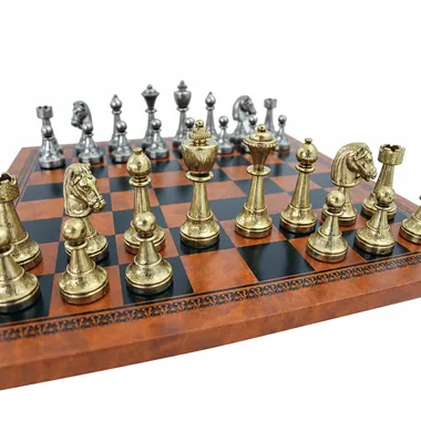 Goldene und silberne Staunton-Figuren aufgereiht auf dem braunen Kunstleder-Schachbrett