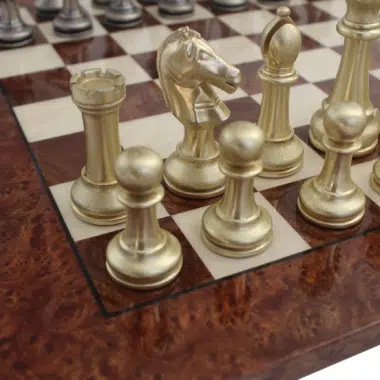 Detailansicht der goldenen Metallfiguren auf dem Schachbrett aus Wurzelholz
