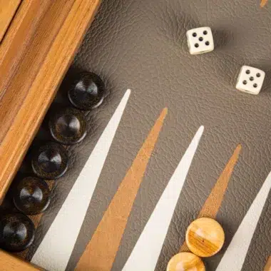 Detail des Backgammon-Bretts mit gestapelten dunklen Steinen und Würfeln