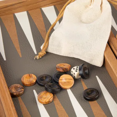 Hölzerne Backgammon-Steine und Würfel auf dem Brett mit Stoffbeutel