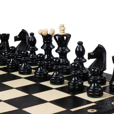 Schachspiel mit schwarzen Figuren in Startposition auf elegantem Brett